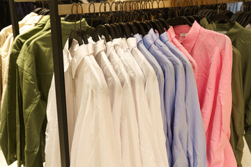 Women's long sleeve shirts hang on hangers in a clothing store.