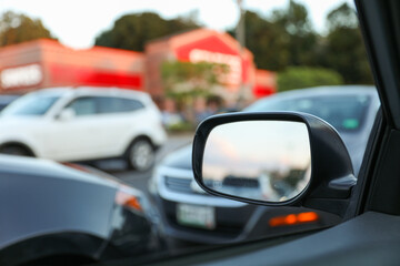 car's rearview mirror, reflecting a scenic road behind. The mirror symbolizes nostalgia, reflection, and the journey of life, capturing moments from the past