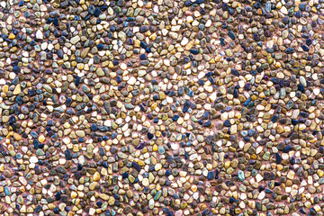 Texture of a brown ceramic stones. Ridge brown background of a facade. Ceramic surface.  Texture from small colored darkly pebble. Mosaic flooring, colored  stones.