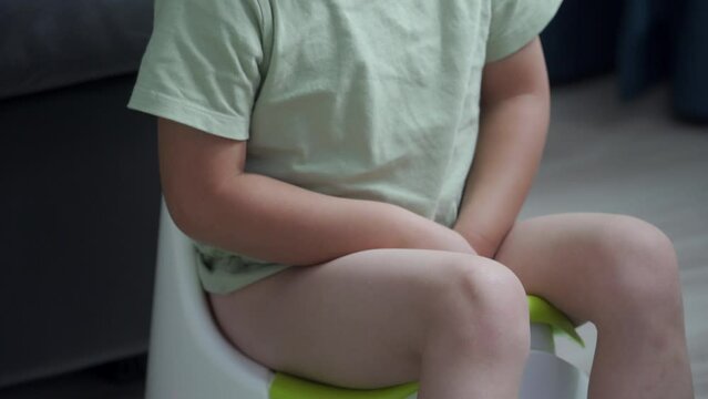 toddler child little boy sitting on a potty in the room