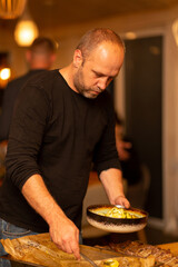 A man puts a baked crookneck on a plate