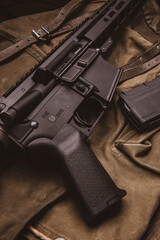 Modern automatic carbine and backpack on a wooden table. A set of fighter ready for any battle...