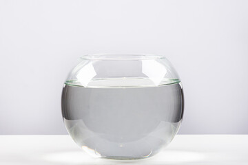 Round aquarium filled with clean water on a white background