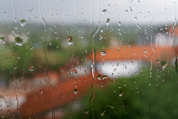Krople deszczu na szybie, rozmyte tło. © Don Pablo