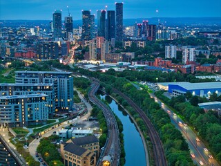 Fototapeta premium Road and railway leading to Manchester downtown. Evening aerial photo. 