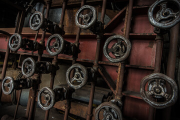 Obraz premium Steering wheels and valves in an abandonend industry complex