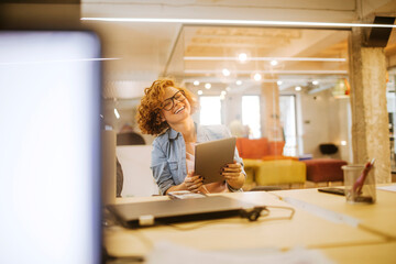 Young Caucasian woman using a tablet in the office of a startup company