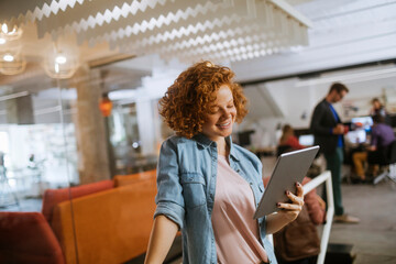 Young Caucasian woman using a tablet in the office of a startup company
