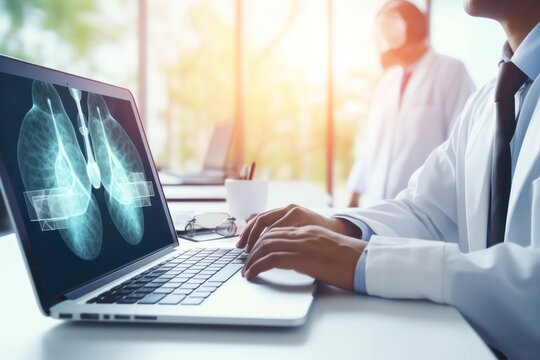 A doctor is seen working on a laptop with a detailed x-ray image displayed on the screen. This image can be used to illustrate medical technology, telemedicine, healthcare professionals, or digital di