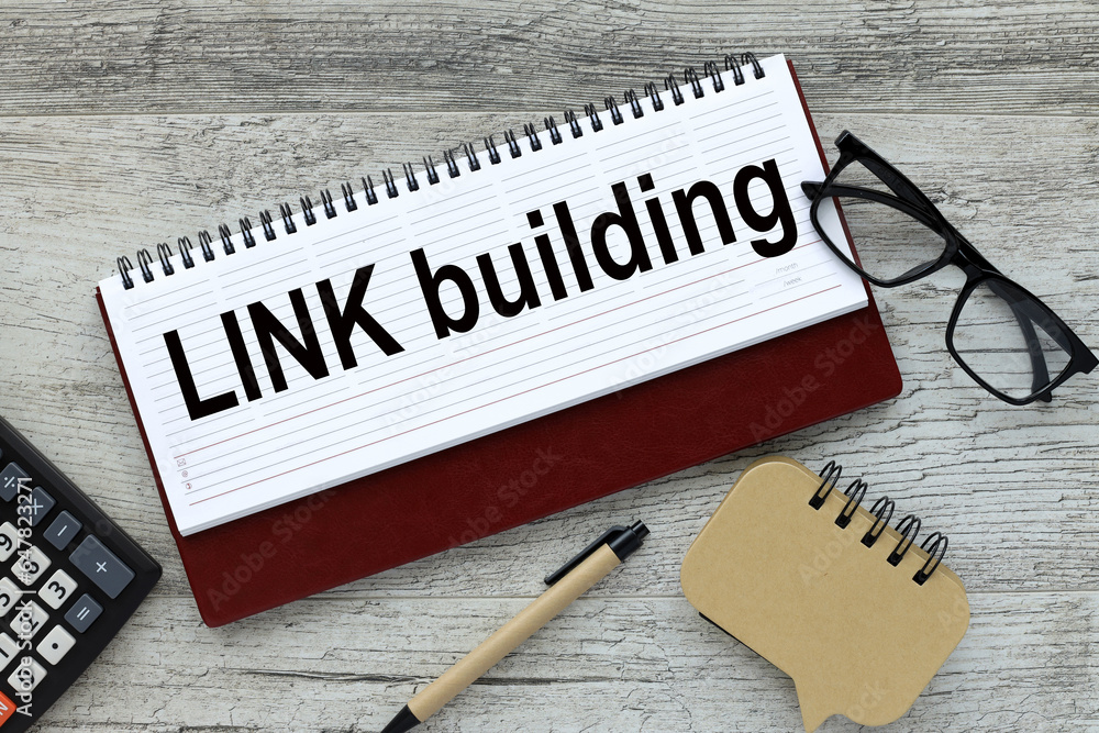 Poster link building notepad with text on wooden background near calculator and glasses