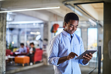 Young african american man using the tablet in a company office