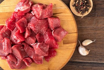 Top view of raw beef or lamb meat, garlic cloves and a mixture of peppers.