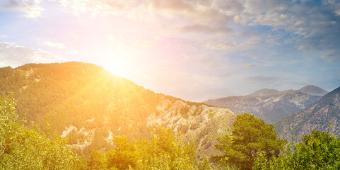 Picturesque mountain slopes with forests and sunrise. Andorra . Wide photo.
