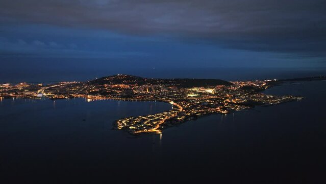 Bird's-eye night view S&egrave;te's coastal poetry, fishing industry, and maritime traditions
