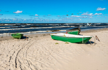 Coastal landscape in autumn with fishing boats anchored at sandy beach of the Baltic Sea