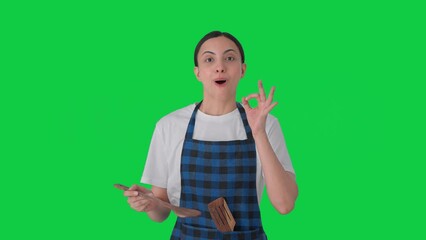 Happy Indian housewife tasting good food Green screen