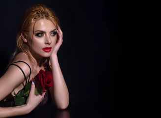 Obraz na płótnie Canvas Sexy woman with red rose. Pretty woman, with red lips, and fashion makeup with roses posing in studio. Beauty and fashion portrait.