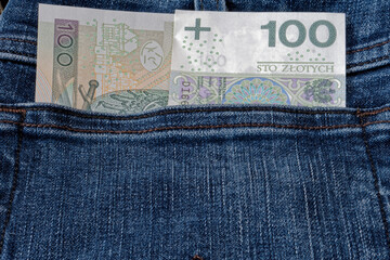 Banknot stuzłotowy w kieszeni jeansów. - obrazy, fototapety, plakaty