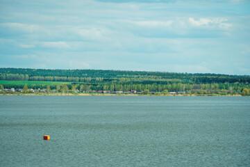 View of the lake among the lush green trees in the forest. Trees grow along the river and are reflected in the clear water. Natural landscape in the forest. River in the forest. uncontaminated nature