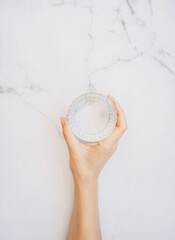 Woman's hand holding a glass of water. Minimal healthy concept
