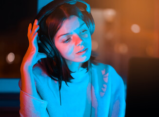 Girl is listening music at home at night. - obrazy, fototapety, plakaty