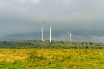 Windmills in a rural area on misty sunrise, Ukraine