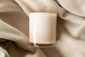 Candle Mockup, Flat lay top view of blank scented candle in glass jar on soft beige tan color fabric