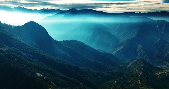 Gorgeous mountains in blue mist. Amazing view of the mountain range in California overgrown with greenery. Top view.