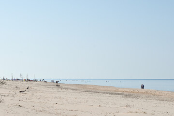 Plaża piaszczysta jesienią, latem. Morze. Nieznana, dzika plaża, gdzieniegdzie kąpią się...