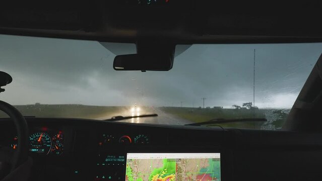  Inside Vehicle View Of Storm Chasers Driving Through Heavy Rain With Radar Screen