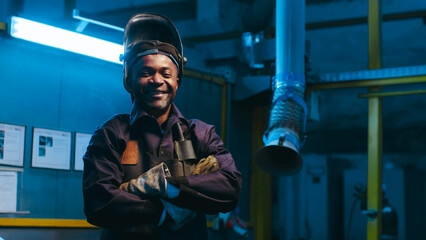African American worker lift up protective mask and smiling. Metal welder dressed up in special...