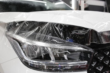 A car wrapping specialist applies a polyurethane film to the car. Selective focus. PPF protective...