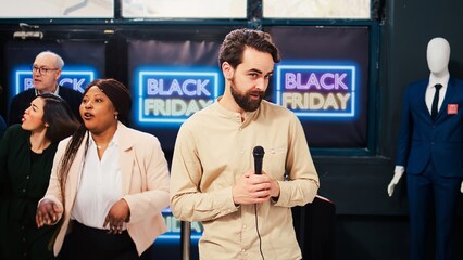 TV reporter standing in front of camera reporting breaking news from black friday event at local...