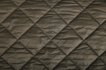 Quilted fabric background. texture blanket or puffer jacket