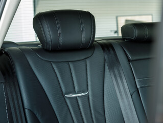 Back passenger seats in modern luxury car, frontal view, black leather