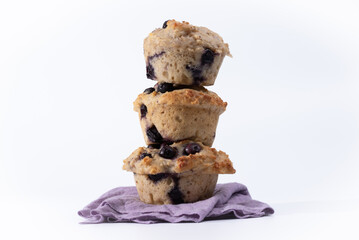 Healthy, blueberry muffins.  Three, oat and blueberry muffins, stacked, one on top of the other.  