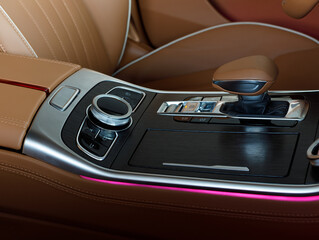 Closeup of multimedia system control buttons on a wood panel in a modern premium luxury car with...