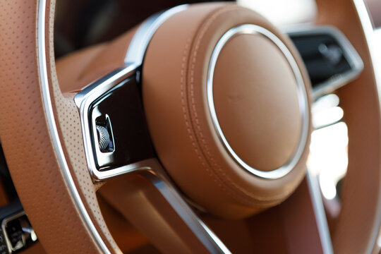 luxury car steering wheel with brown leather and touch control buttons