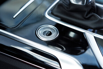 Naklejka premium Engine Start Stop button on modern luxury car. black glossy design dashboard