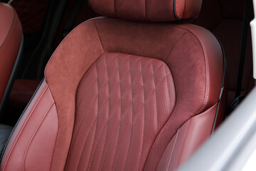 Fototapeta premium Part of red leather luxury car seat. Macro shot 