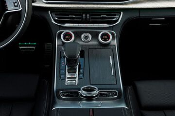 Black wood, aluminum buttons, Automatic transmission, climate control and air vents in a modern car