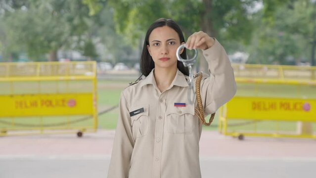 Indian female police officer posing with handcuffs