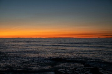 Obraz premium beautiful orange and blue background of a beach during the sunset in california on the west coast