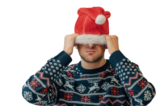 young man or teenager in christmas at home angry with santa claus hat