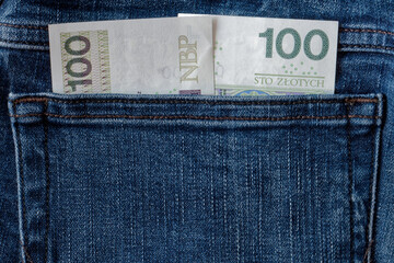 Banknoty stuzłotowe w kieszeni jeansów. - obrazy, fototapety, plakaty