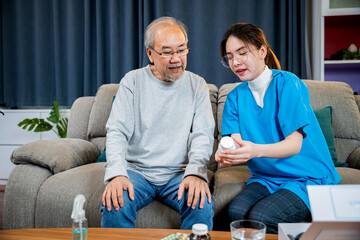 Woman nurse caregiver showing prescription drug to senior man at nursing home, healthcare support, Asian doctor with physician visit senior male patient consult medicine dosage at house in living room