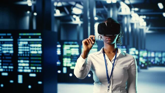 African american trained admin immersed in virtual reality at data center, doing units maintenance. Capable expert using VR headset to optimize servers performance, checking operations