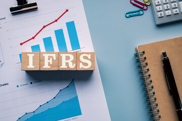 There is wood cube with the word IFRS. It is an abbreviation for International Financial Reporting...