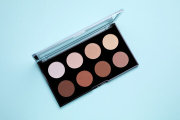 Colorful contouring palette on light blue background, top view. Professional cosmetic product