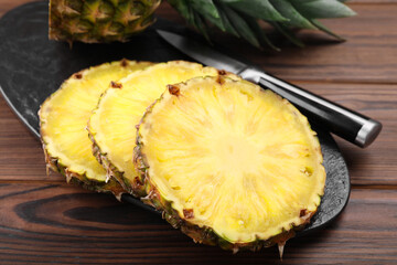 Pieces of tasty ripe pineapple on wooden table, closeup